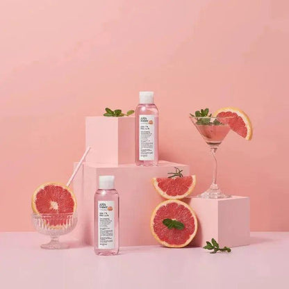 SKINFOOD Pink Grapefruit AHA Toner 200ml displayed with fresh grapefruits in a vibrant pink setting.