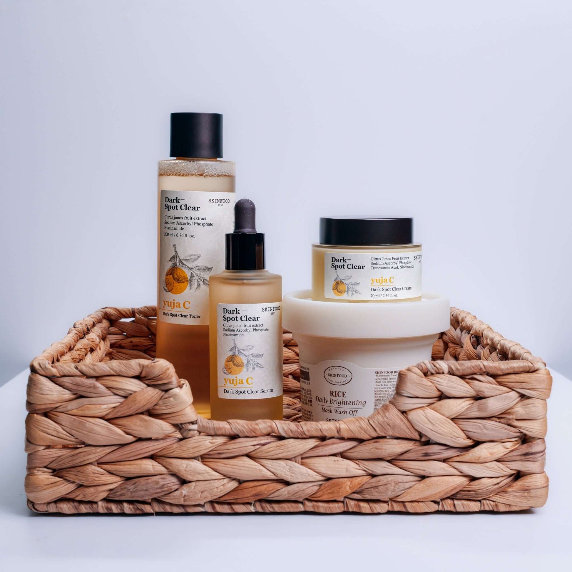 SKINFOOD - Yuja C Dark Spot Clear Toner 200ml products displayed in a basket for skincare routine.